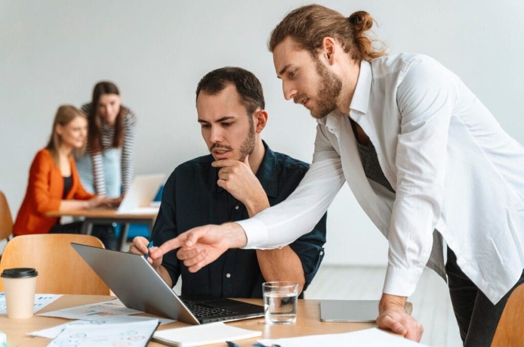 Équipe discutant d'un projet sur un ordinateur portable, formation CSE
